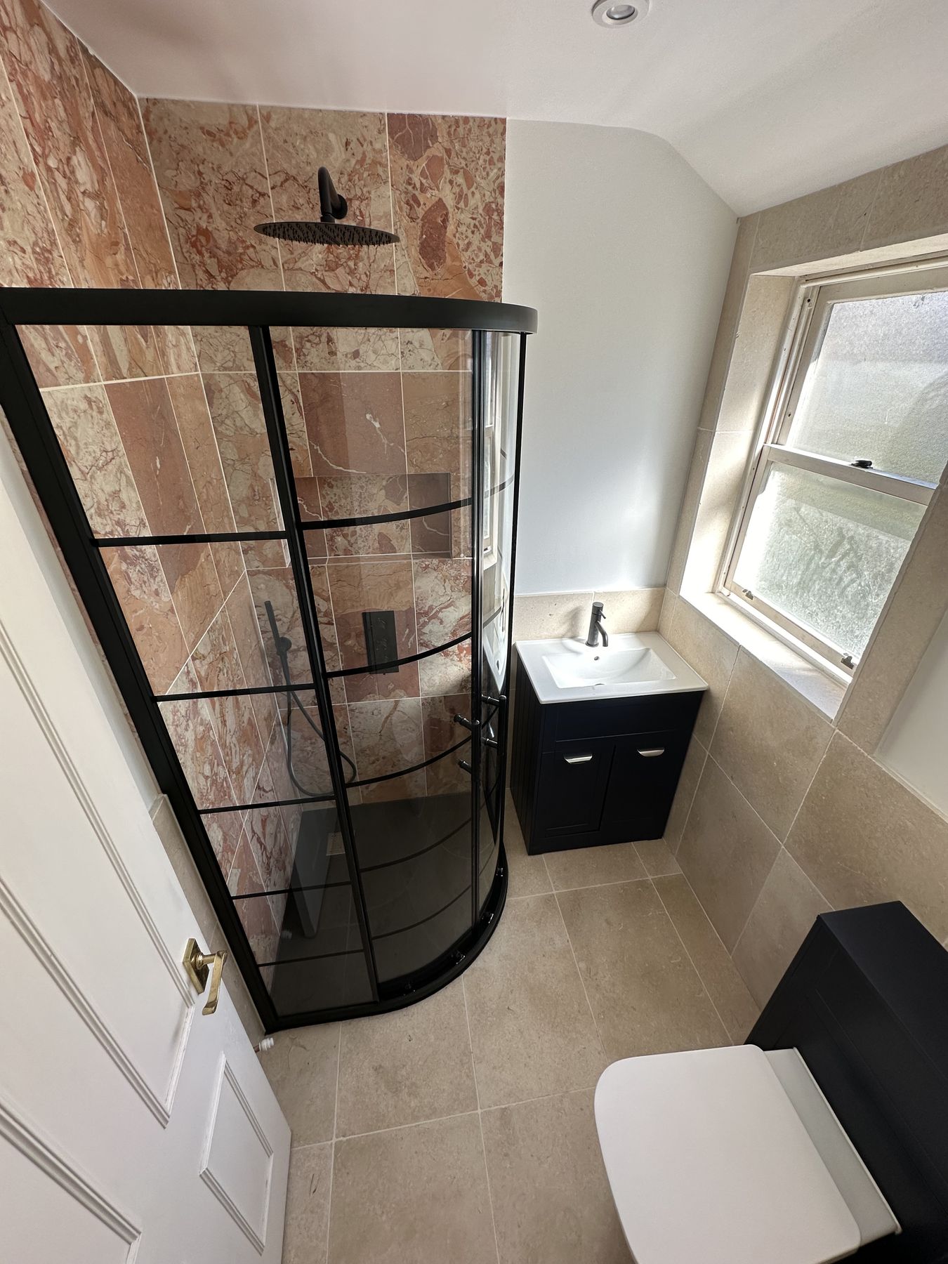 Curved black-framed enclosure and a black vanity